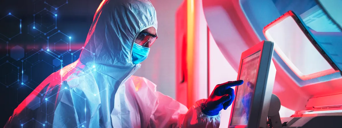 Image of a healthworker in protective clothing using a computer screen